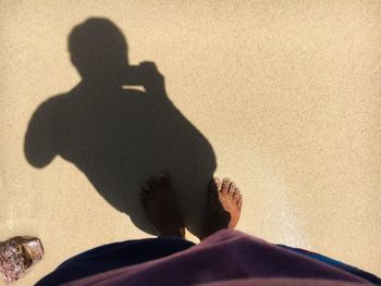 Shadow of person on sand at beach