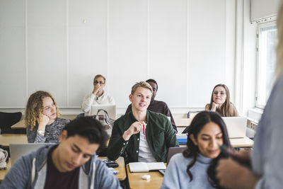 Young man sitting at desk in university classroom