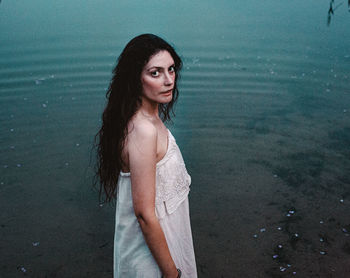 Portrait of young woman standing in the water 