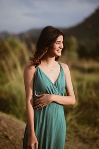 Young woman standing against sky