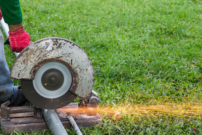 Low section of person holding umbrella on field