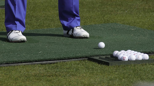 Low section of man playing golf on field