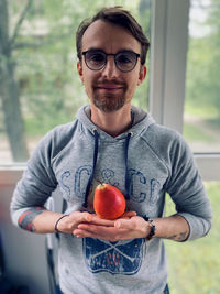 Portrait of smiling man holding apple 