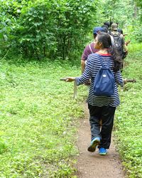 Rear view of friends standing in forest