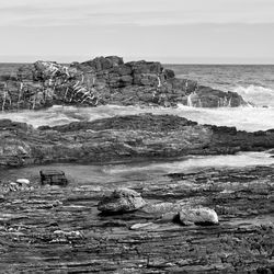 Scenic view of rocks on beach against sky