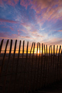 Wooden fence against orange sky