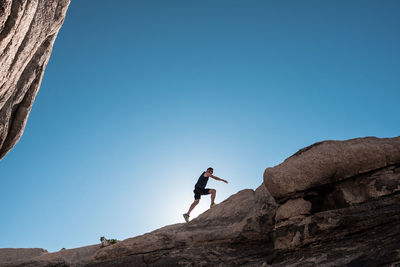 Low angle view of rock formation against clear blue sky