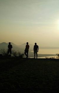 Silhouette of people on beach at sunset