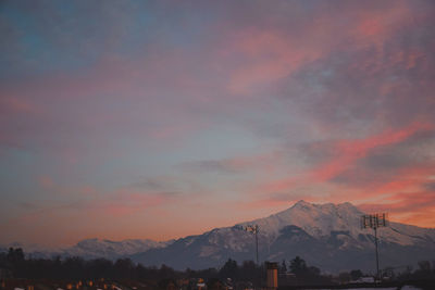 Scenic view of snowcapped mountains against orange sky