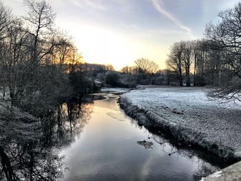 Scenic view of river against sky during winter