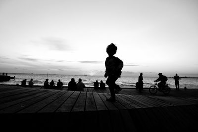 People at beach against sky