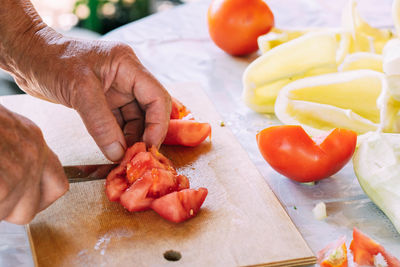 Cropped hands of man preparing food on cutting board