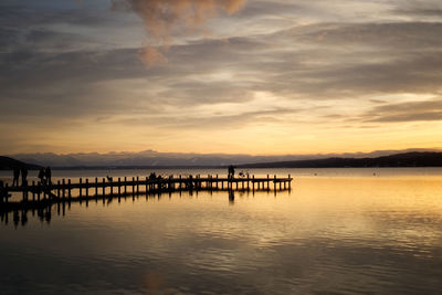 Pier on sea against sky during sunset