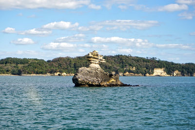 Rock formations in sea against sky