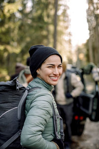 Side view of happy woman with backpack