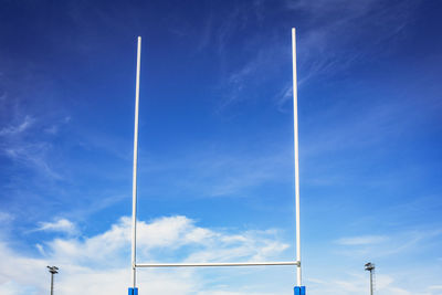 Low angle view of street lights against blue sky