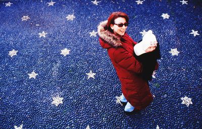 Portrait of smiling young woman against blue wall