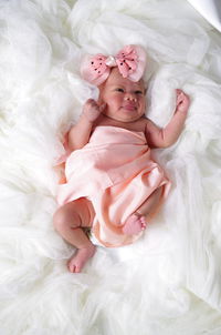 High angle view of cute baby girl lying on bed at home