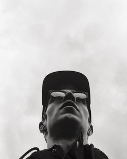 Low angle view of man in sunglasses and cap against sky