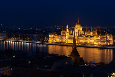 Illuminated city against sky at night