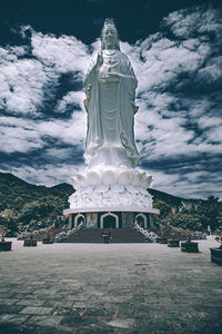 Statue of buddha against cloudy sky