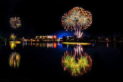 Firework display over lake at night