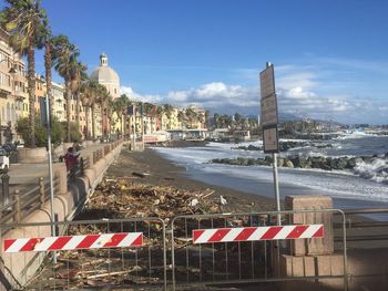 Road by buildings against sky in city