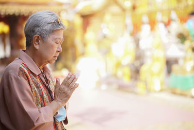 Side view of man looking at camera