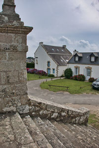 Exterior of old building by houses against sky