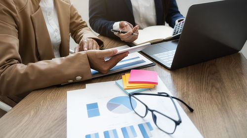 Midsection of businessman working on table