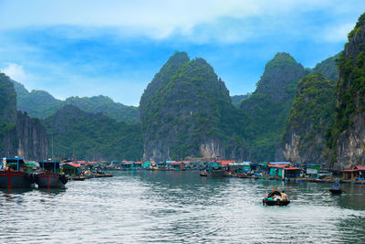 Boats in sea against mountains