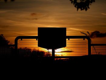 Silhouette basketball hoop against sky during sunset