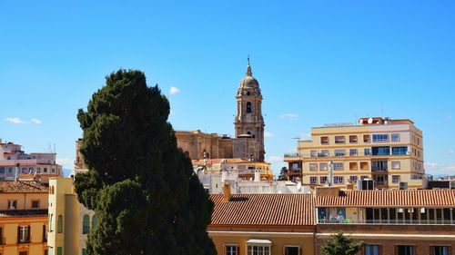 View of cathedral in city against blue sky