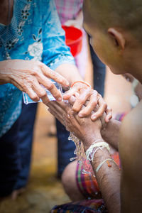 Woman washing man hand outdoors