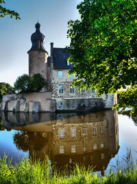 Reflection of building in lake against sky