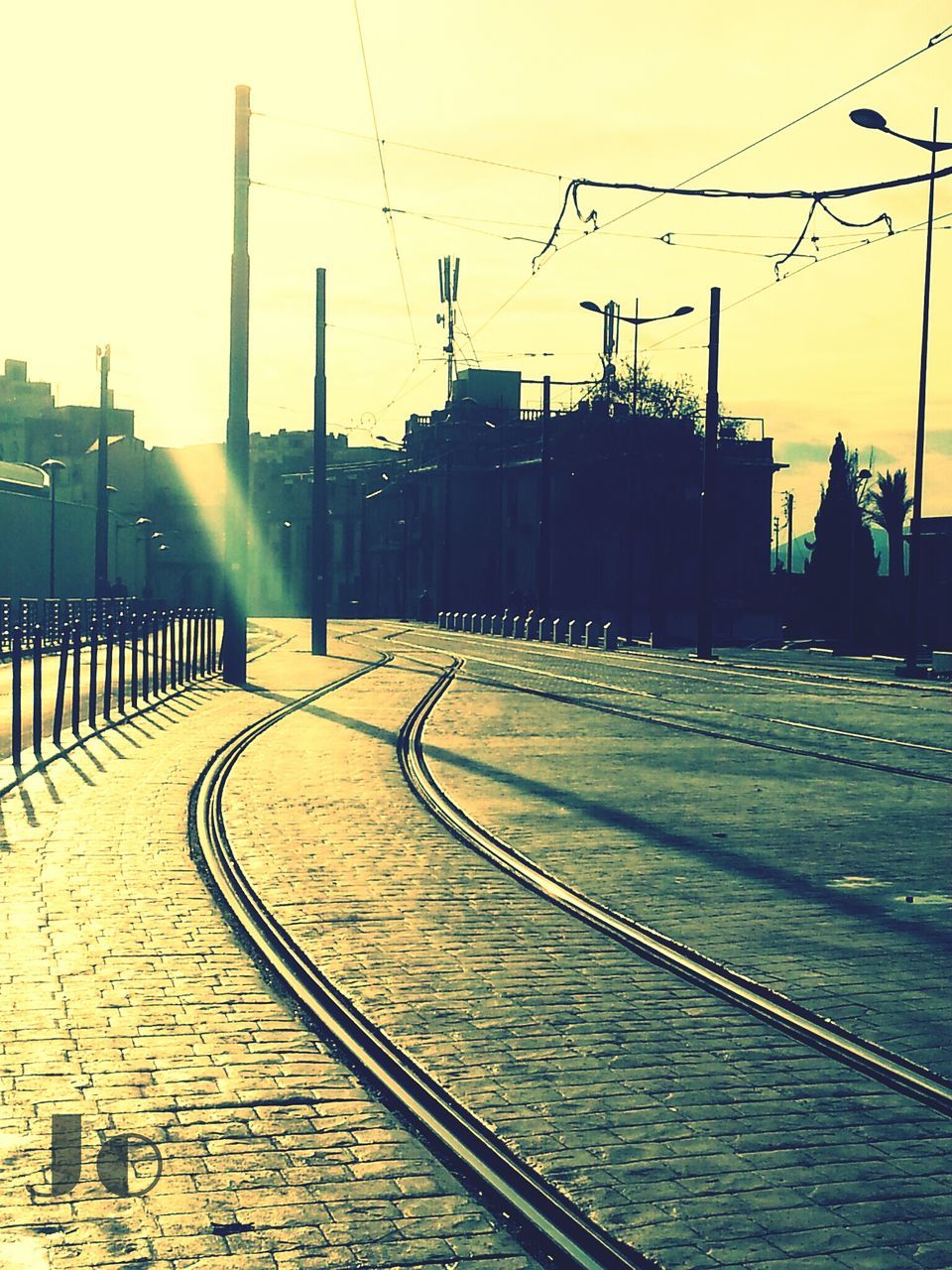 built structure, sunset, building exterior, architecture, railroad track, clear sky, electricity pylon, power line, transportation, connection, electricity, sunlight, cable, the way forward, sky, street light, rail transportation, city, outdoors, fuel and power generation