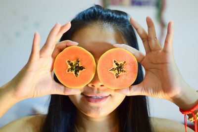 Close-up of woman holding papaya slices