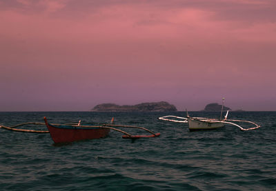 Boats moored on sea against sky