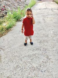 Portrait of cute girl standing on footpath