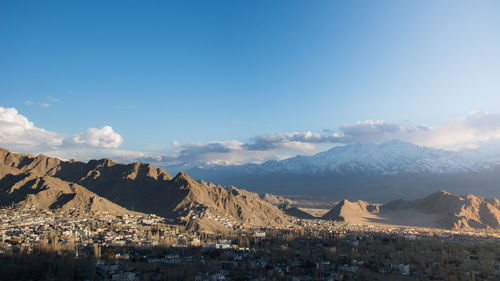 Panoramic view of townscape and mountains against sky