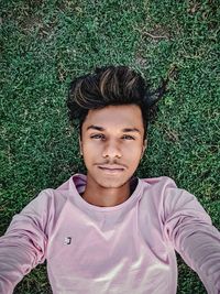 Portrait of young man lying on field