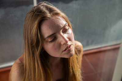 Close-up high angle view of thoughtful young woman looking away outdoors