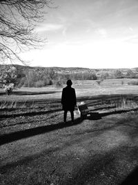 Rear view of silhouette man standing on field against sky