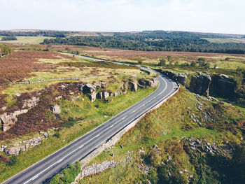 High angle view of road amidst field against sky