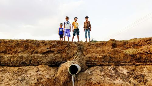 People standing on land against sky