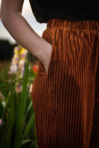 Midsection of woman with hand in pocket standing outdoors