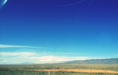 Scenic view of landscape against blue sky