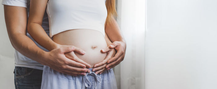 Midsection of woman touching mirror