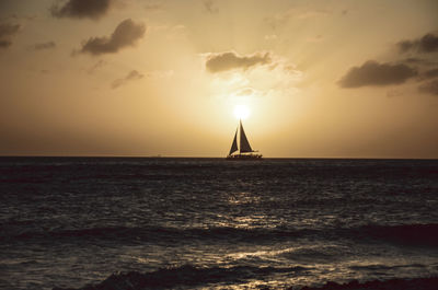 Sailboat sailing on sea against sky during sunset