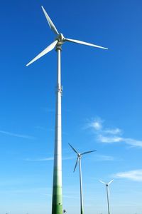 Low angle view of traditional windmill against blue sky